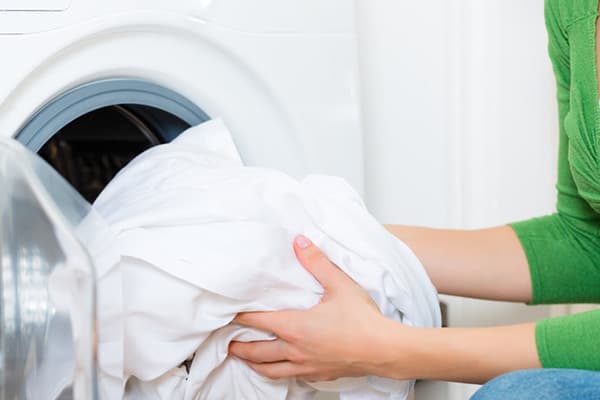 Lavar ropa blanca en la lavadora.
