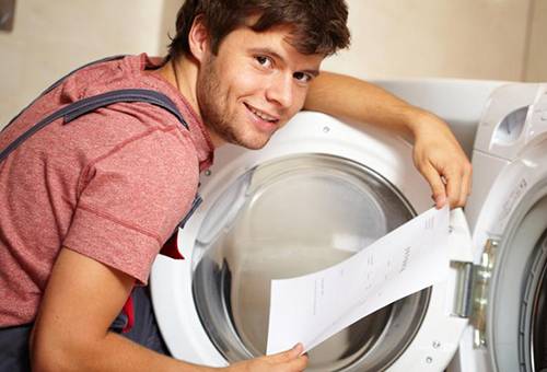 Mees uurib pesumasina juhiseid