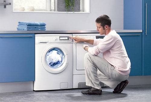 Un hombre comprueba el funcionamiento de la lavadora.