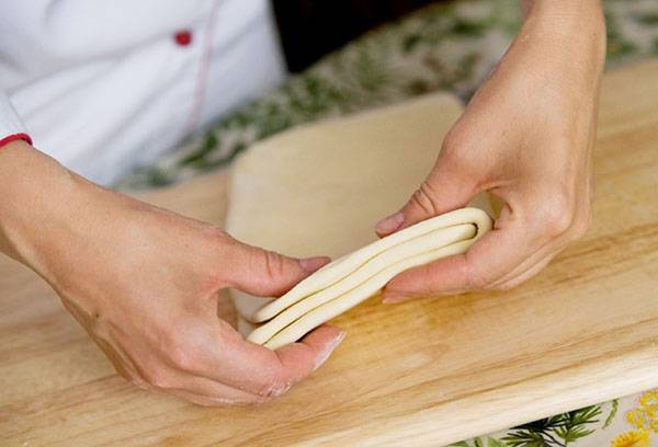 Bladerdeeg in de handen van een chef-kok