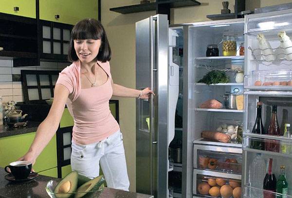 Naine võtab külmkapist toitu välja