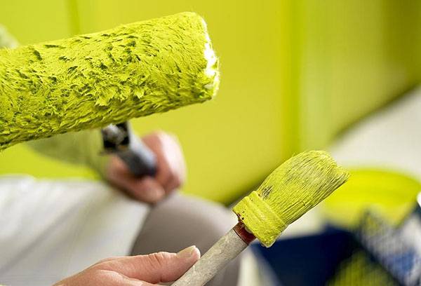 Roller and brush in paint