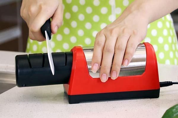 Afilar un cuchillo de cerámica con afilador eléctrico.