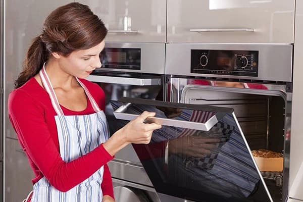 Batang babae na naghahanda ng pie sa oven