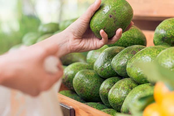 Seleção de abacates em um supermercado