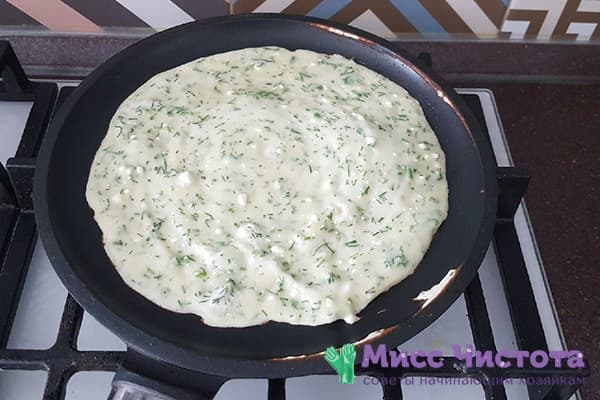 Dough with cheese and herbs in a frying pan