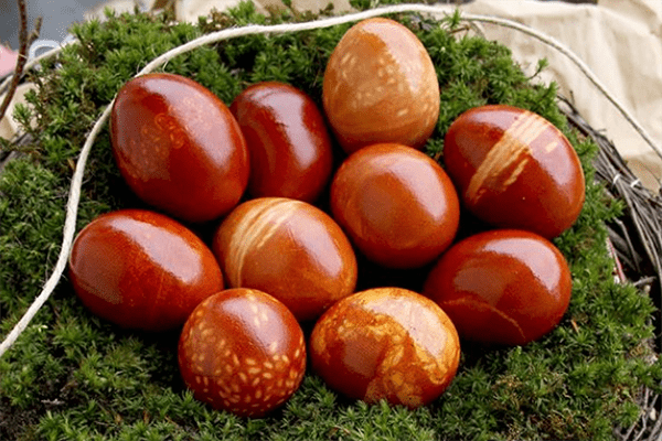 Huevos teñidos con piel de cebolla usando hilo y arroz