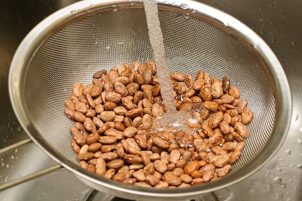 Banlawan ang beans sa ilalim ng tubig na tumatakbo