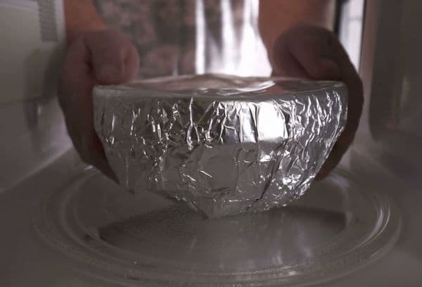 Colocar platos envueltos en papel de aluminio en el microondas