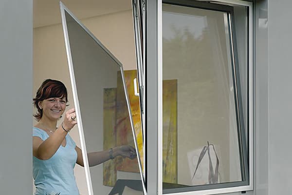 Mujer quitando la pantalla de la ventana