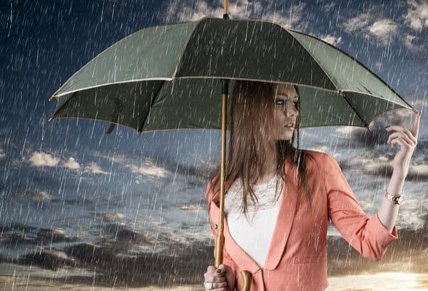 Chica con paraguas bajo la lluvia