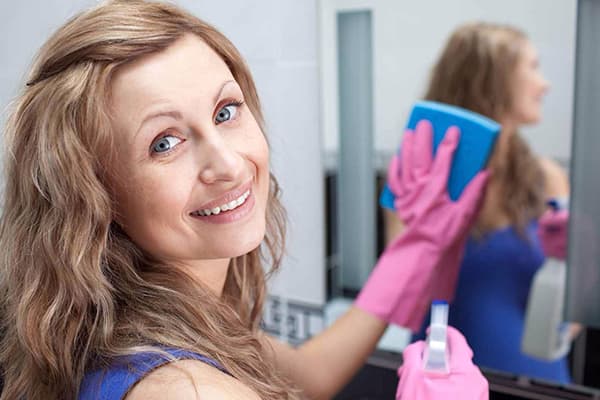 Woman washing a mirror