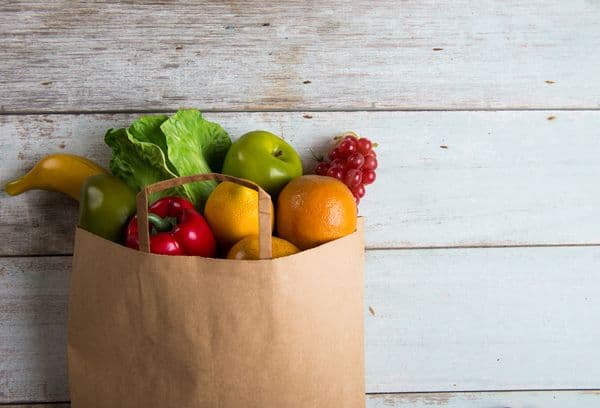 Saco de papel com legumes e frutas