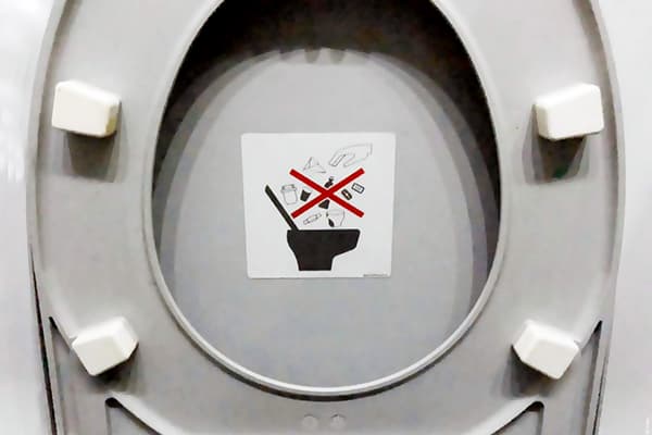 Etiqueta que prohíbe tirar basura al baño.