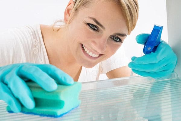 Mujer limpiando refrigerador