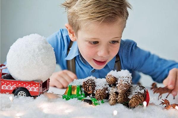 Niño jugando con nieve artificial