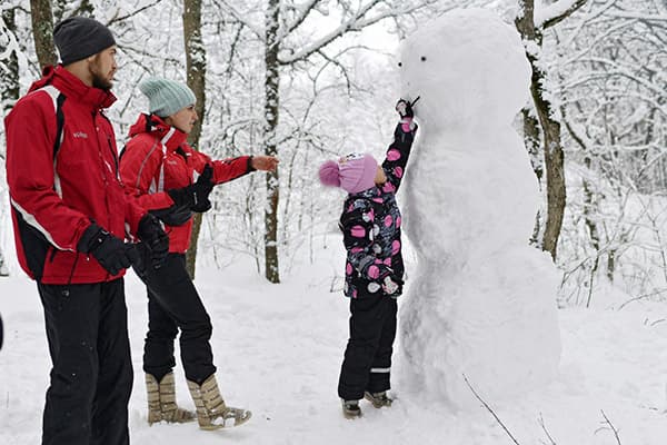 Familia haciendo un muñeco de nieve.