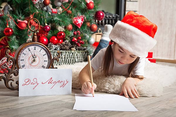 Una niña le escribe una carta a Papá Noel.