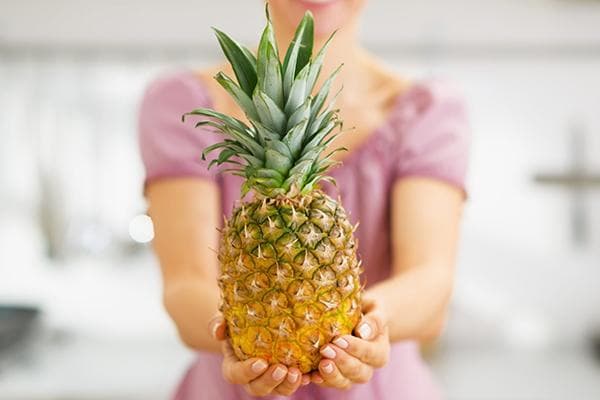 Chica sujetando piña 