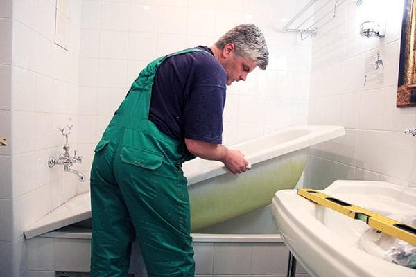 Instalación de un inserto acrílico en una bañera.