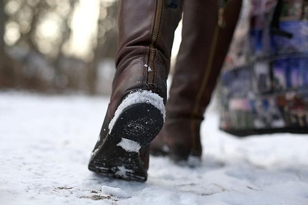 Mujer caminando con botas en la nieve.