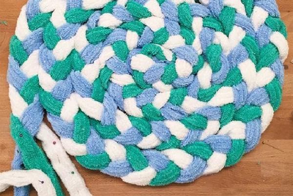 Tejer una alfombra con trenzas de trapo.