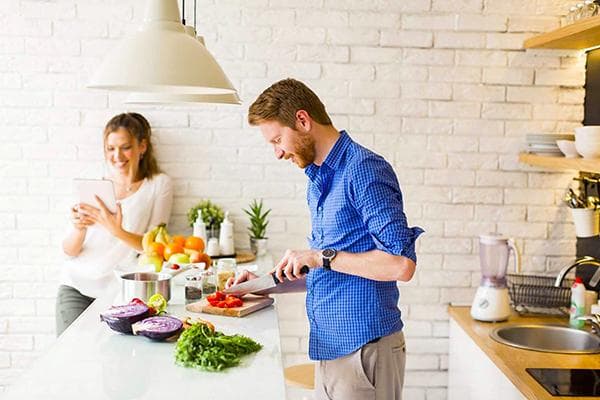 Un hombre cocina comida para dos.