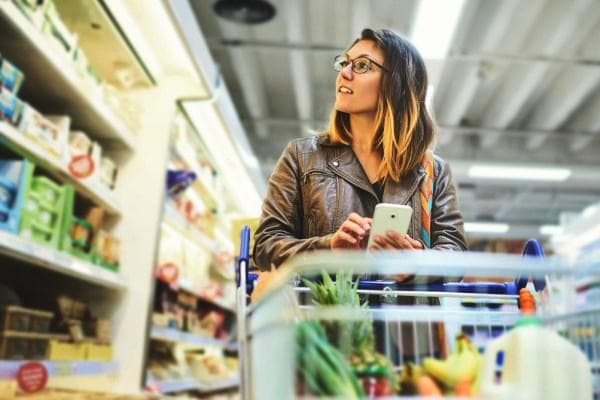 Femme achetant des produits d'épicerie à partir d'une liste