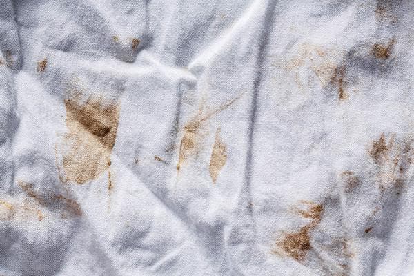 Manchas de óxido en una camiseta blanca después del lavado.