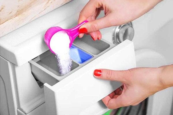 Verter detergente en polvo en la lavadora