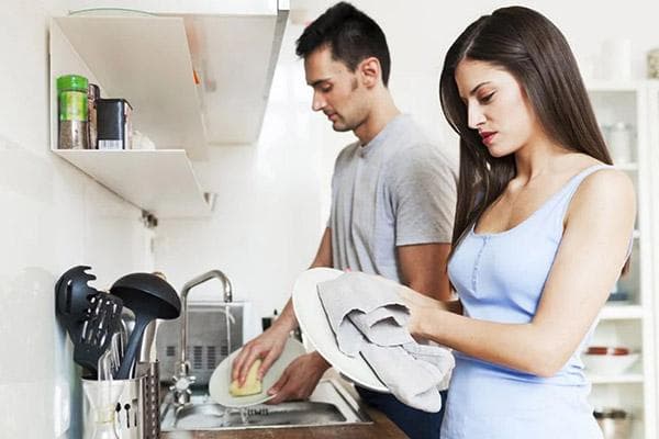Hombre y mujer lavando platos