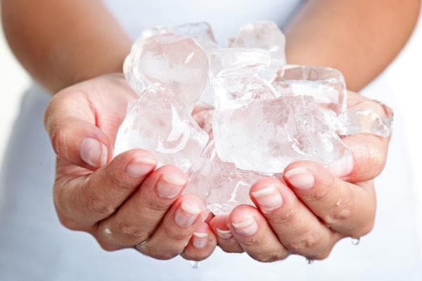 Cubitos de hielo en las manos