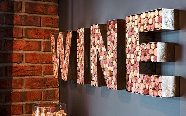 Decoración tipo loft en forma de palabra VINO hecha con corchos de vino.