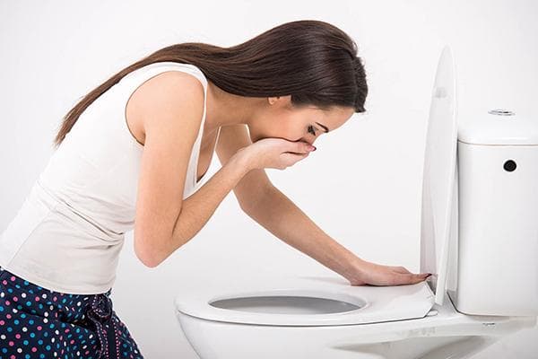 Das Mädchen erbricht sich in der Toilette