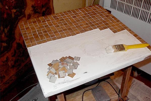 Decorar una mesa en la casa de campo con un mosaico hecho con restos de linóleo