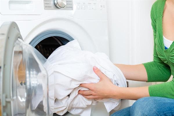 Cargar ropa de cama en la lavadora