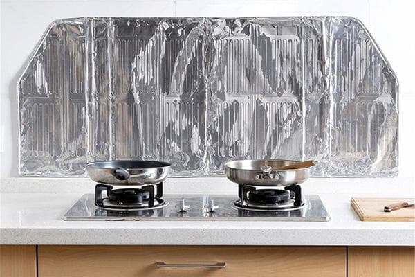Pantalla protectora de papel de aluminio para delantal de cocina cerca de la estufa