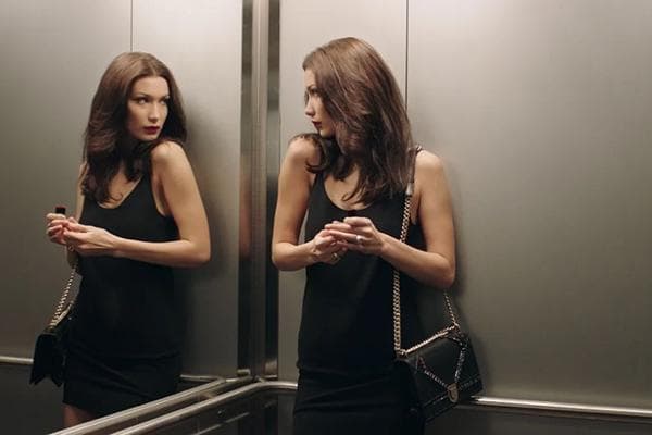 Chica en un ascensor con espejo.