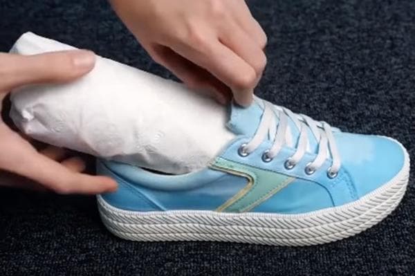 Secador de zapatos hecho con una botella de agua y papel higiénico.