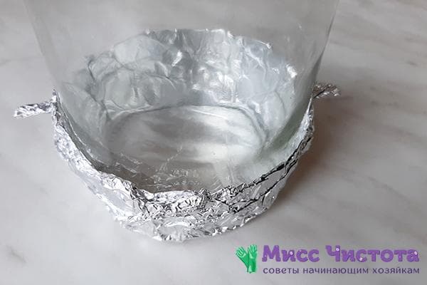 Frasco de vidrio envuelto con papel de aluminio en el fondo.