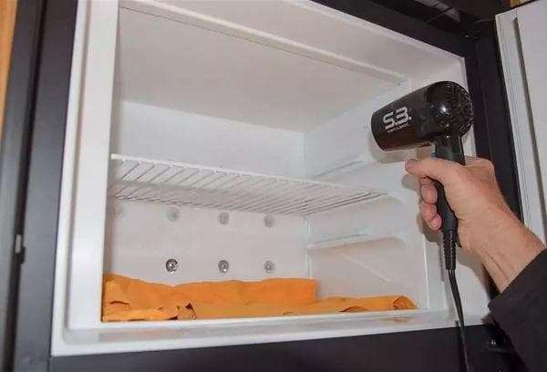 Descongelar el frigorífico con secador de pelo.