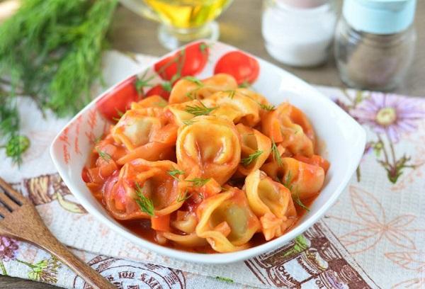 Gebakken dumplings met tomatenpuree in een koekenpan